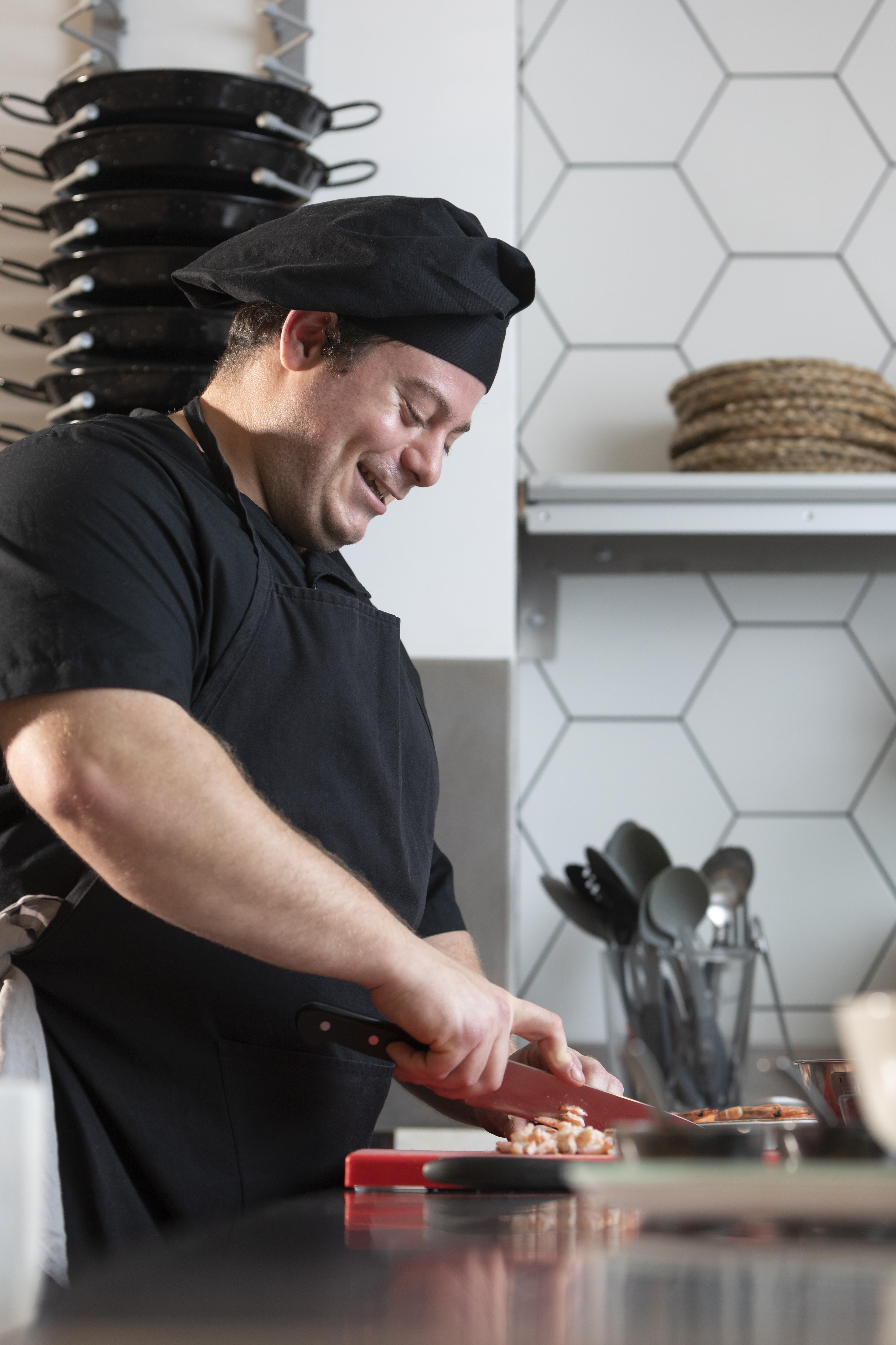 male chef cooking while smiling